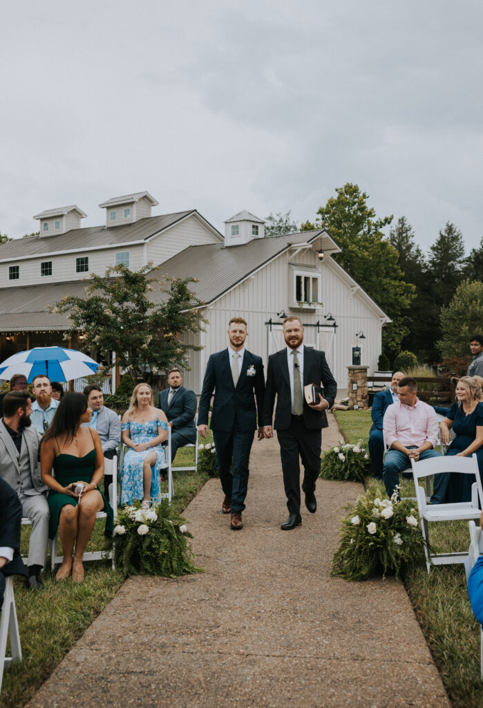 Groom and his officiant cheerfully walking down the aisle 