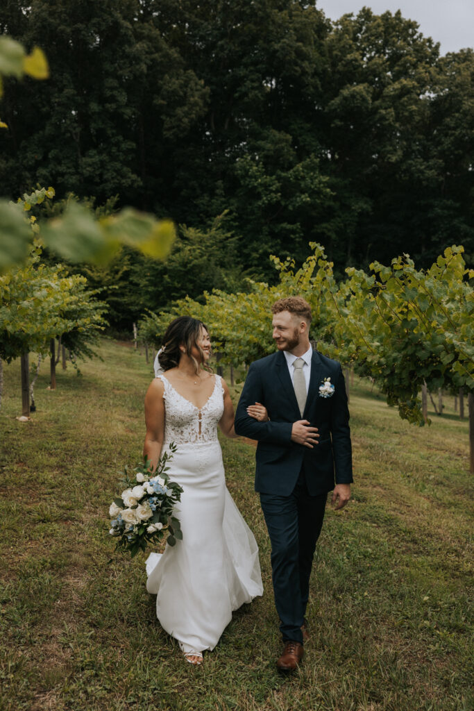 Wedding Photography Bride and Groom walking through the vineyards together 