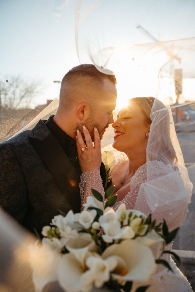 Bride and groom under veil with the help of second photographer 