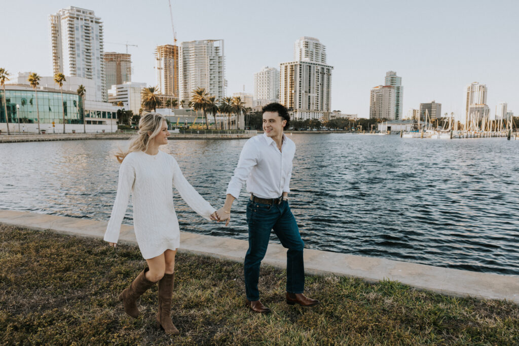 Couple walking in front of St. Pete city skyline