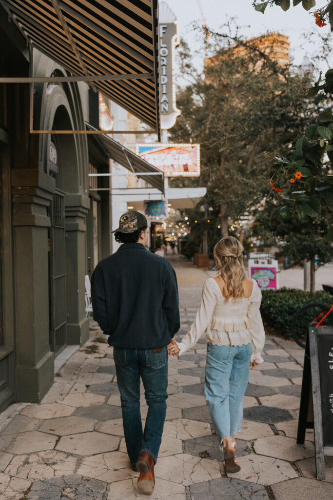 Couple holding hands walking through downtown, St. Pete