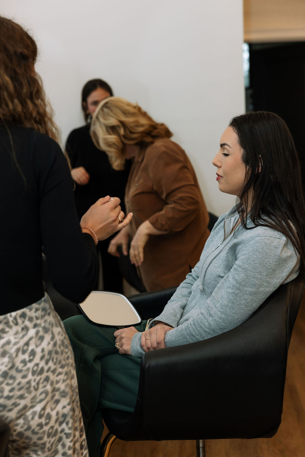 Bride seated during hair and makeup in the getting-ready suite while vendors prepare the morning timeline, a glimpse into what do wedding planners do to keep the day steady from the start.