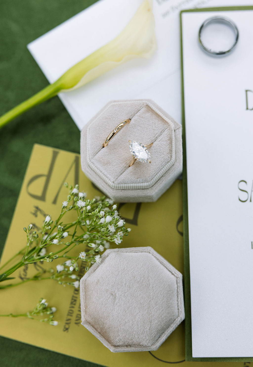 Wedding invitation suite with green and gold details, engagement ring, and floral accents styled on velvet, part of a thoughtfully planned Tennessee wedding day.