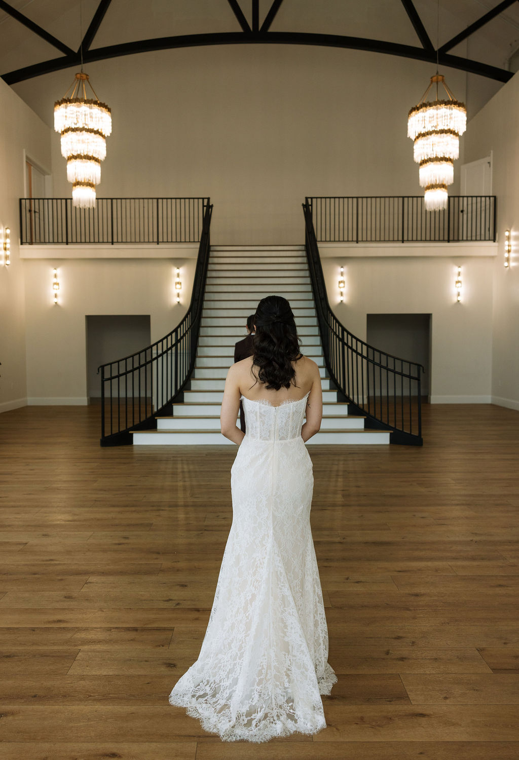 Bride standing at the base of the grand staircase inside Nichols Heir in Tennessee, elegant indoor portrait made possible by a well-executed rain plan.