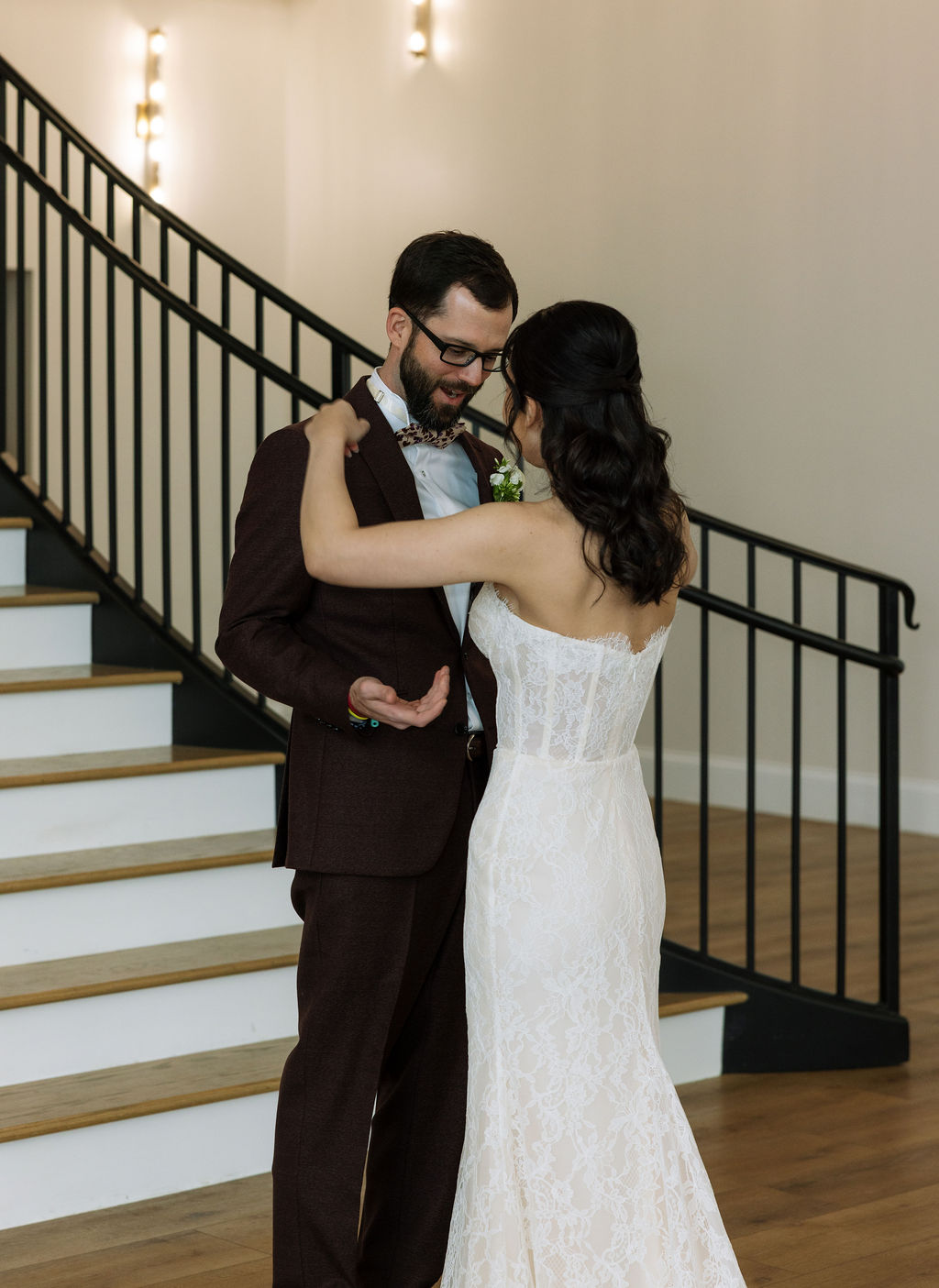 Bride and groom embracing near the staircase at Nichols Heir, indoor portrait captured during a rain-adjusted Tennessee wedding timeline.