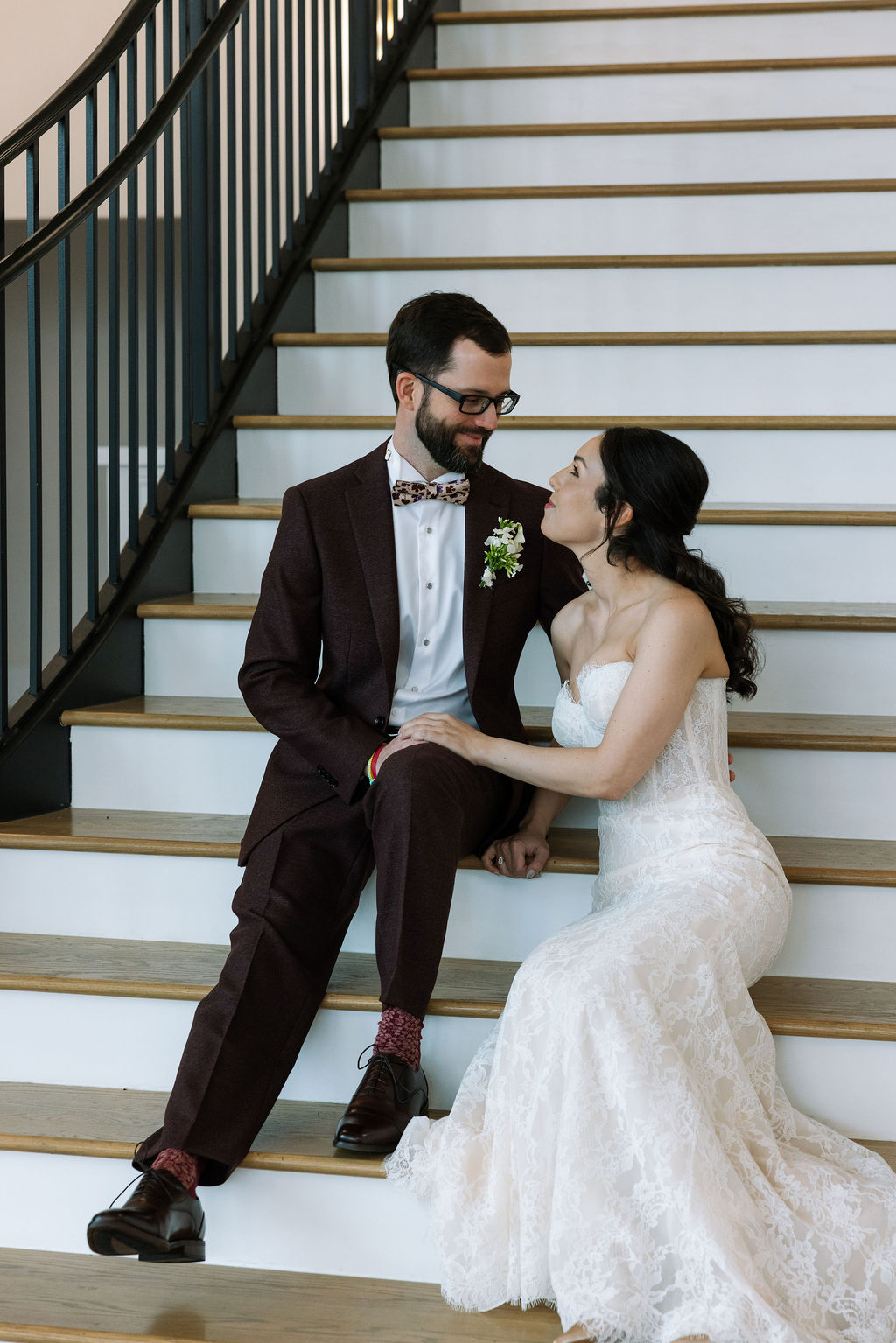 Bride and groom seated together on the grand staircase at Nichols Heir in Tennessee, relaxed indoor moment during a rain-adjusted wedding timeline.