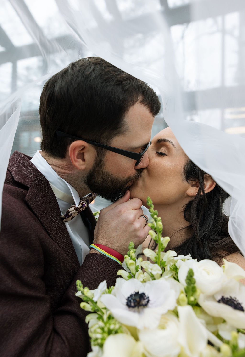 Close-up of bride and groom kissing beneath the veil at Nichols Heir, intimate rainy-day portrait showing how preparation and calm leadership shape what do wedding planners do in real moments.