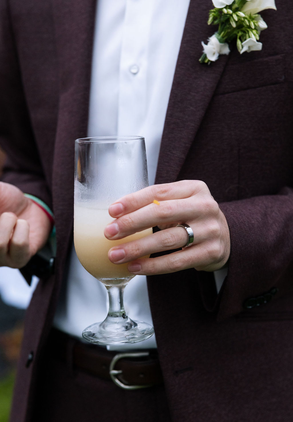 Close-up of groom holding a signature cocktail during reception, candid moment during a well-paced Tennessee wedding evening.
