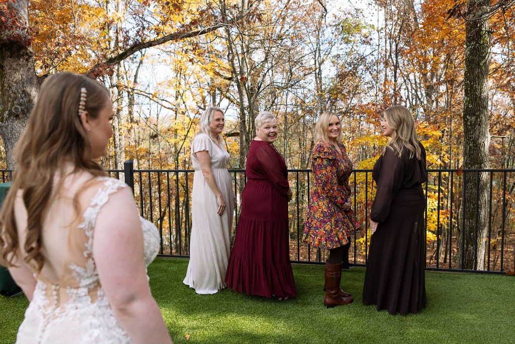 Bride walking across grass to her family to see her for the first time in her wedding dress at Smoky Mountain wedding venue