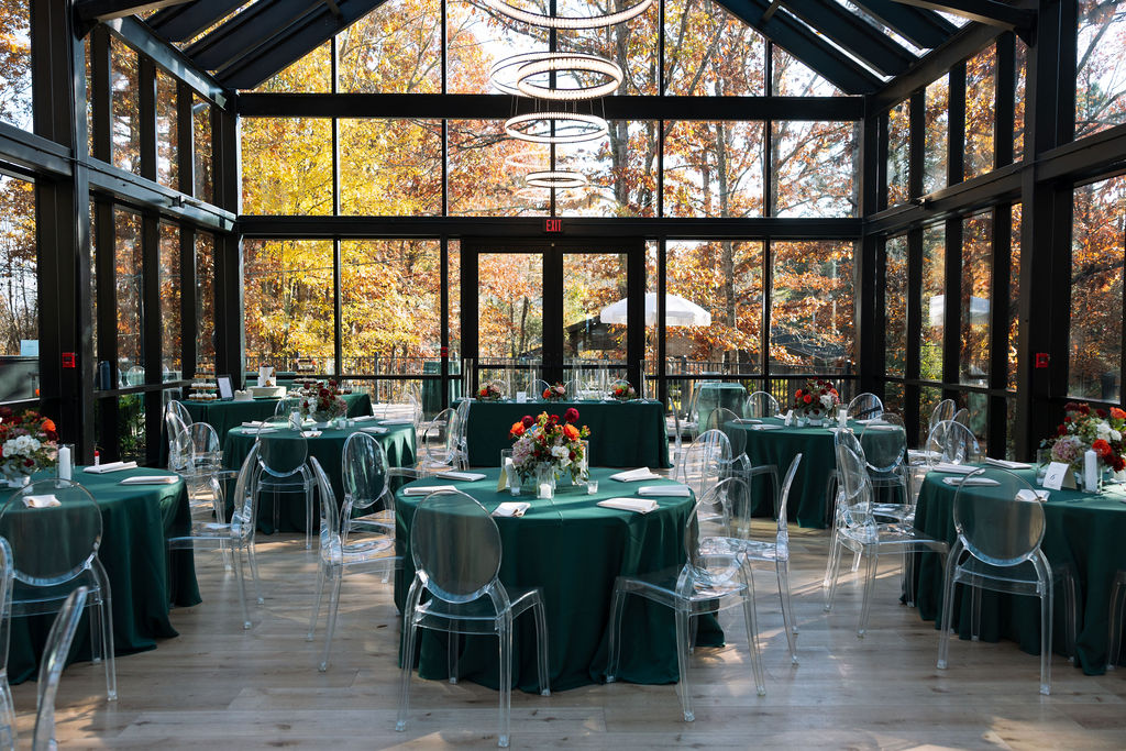Inside of indoor glass house at Smoky Mountain wedding venue surrounded by fall scenery overlooking the Smokies. 