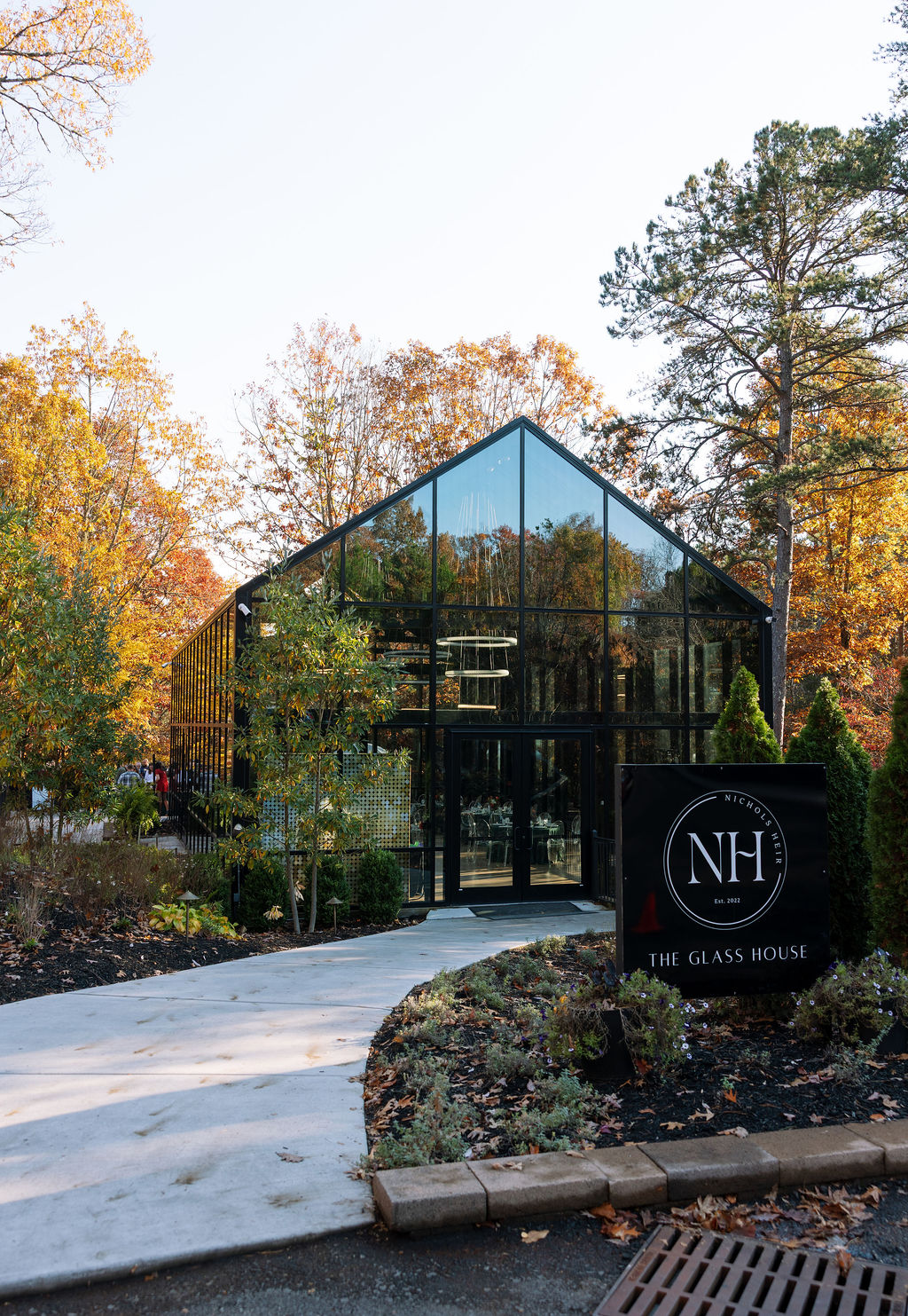 Outside of the Glass House at Nichols Heir surrounded by beautiful fall foliage before wedding ceremony. 