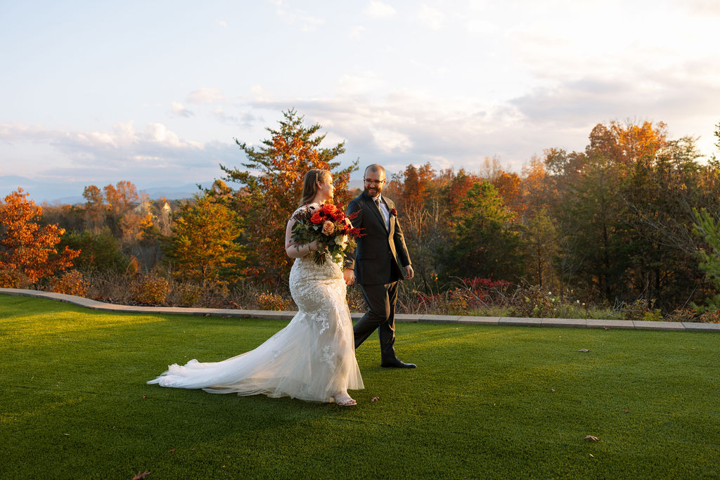 Bride and groom walking hand in hand during golden hour after wedding ceremony at Smoky Mountain wedding venue. 