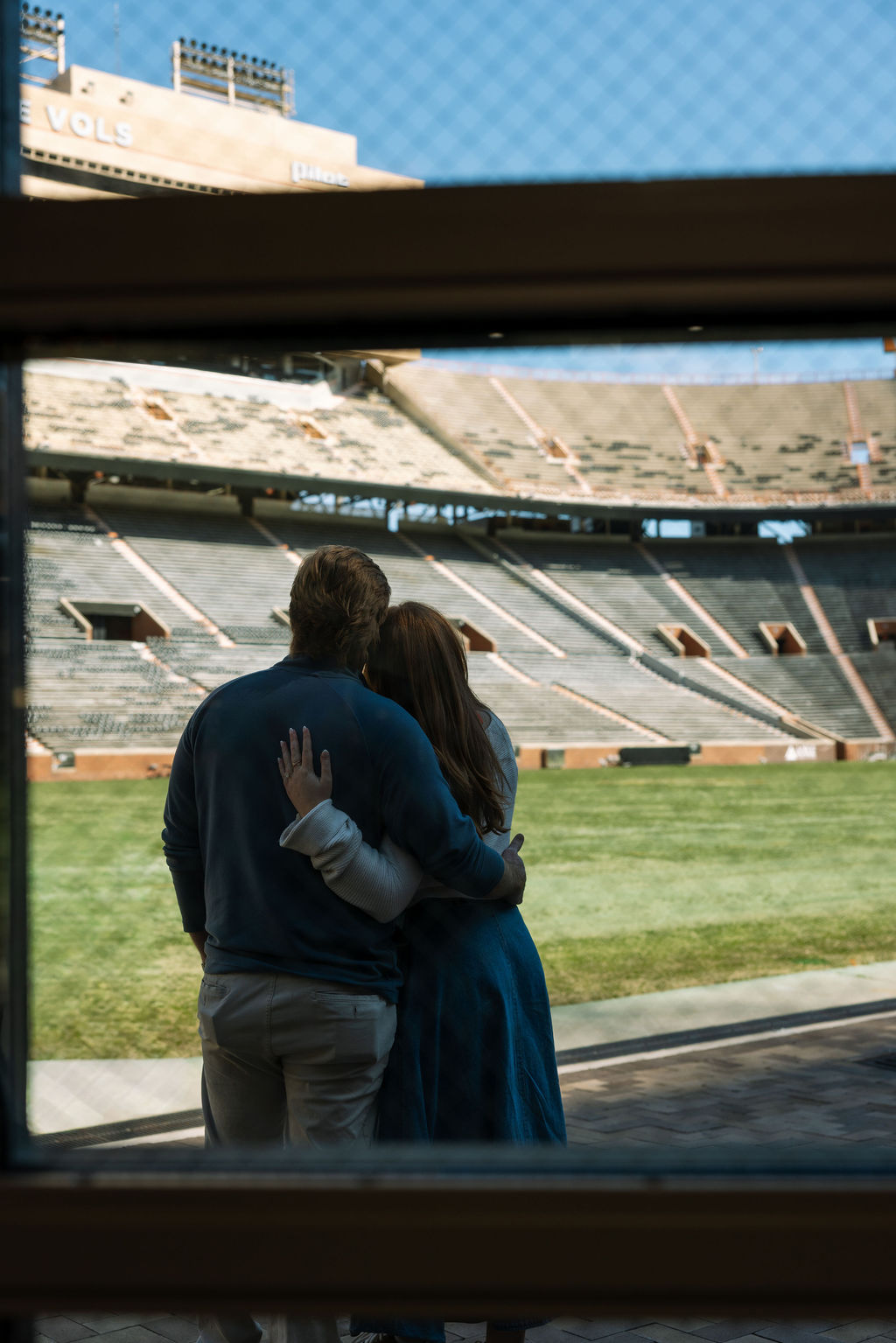 Engaged couple overlooking Neyland Stadium field after their surprise proposal in Knoxville