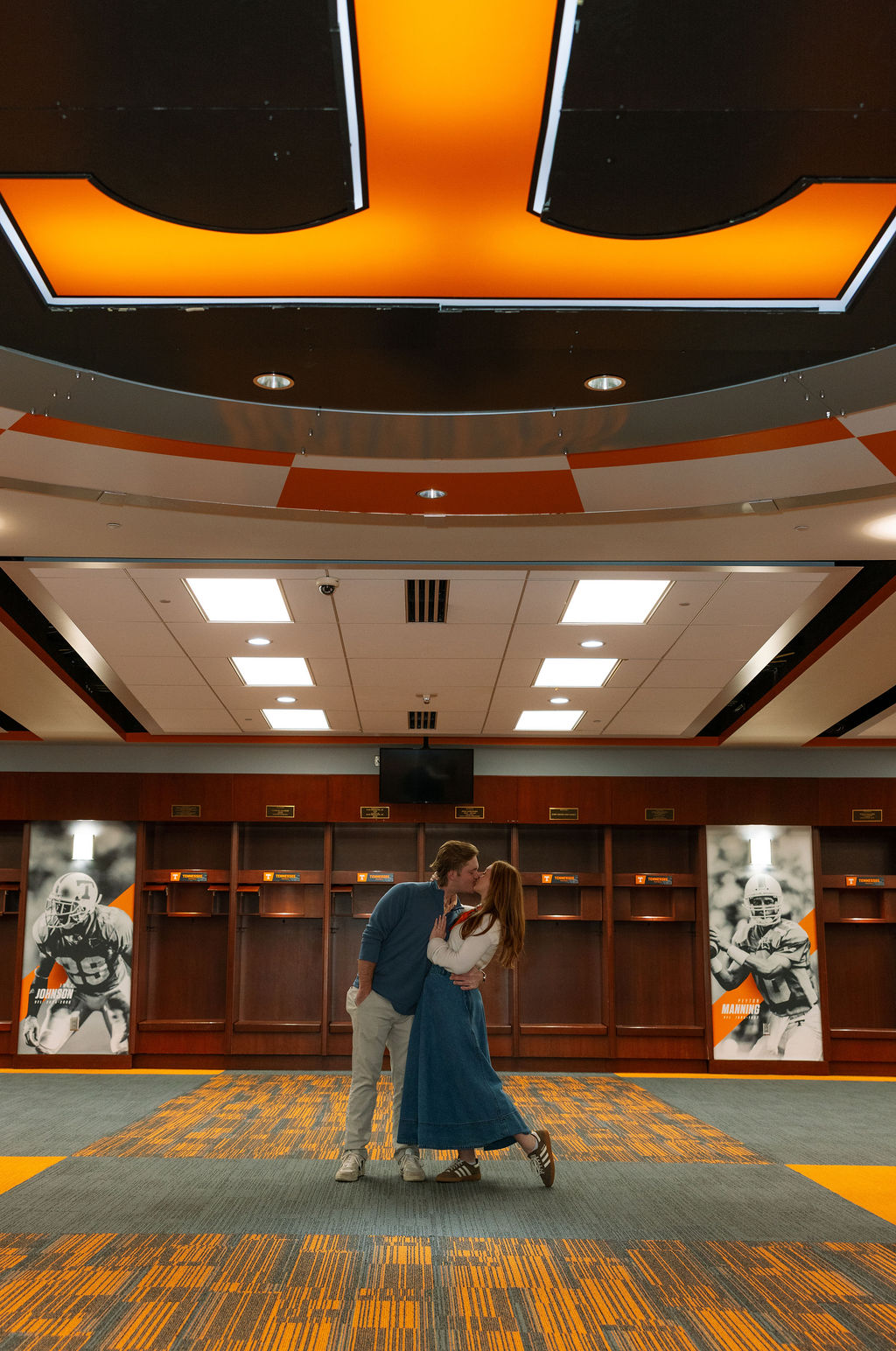 Couple kissing inside University of Tennessee football locker room after surprise proposal
