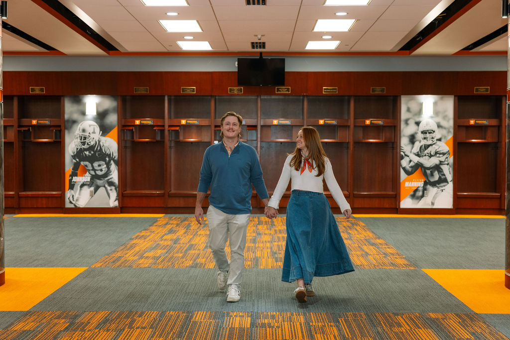 Couple walking through University of Tennessee football locker room after surprise proposal