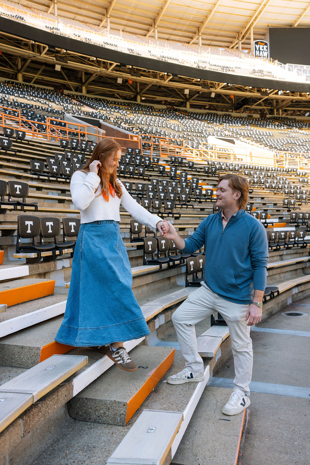 Couple walking through Neyland Stadium seating after surprise proposal in Knoxville