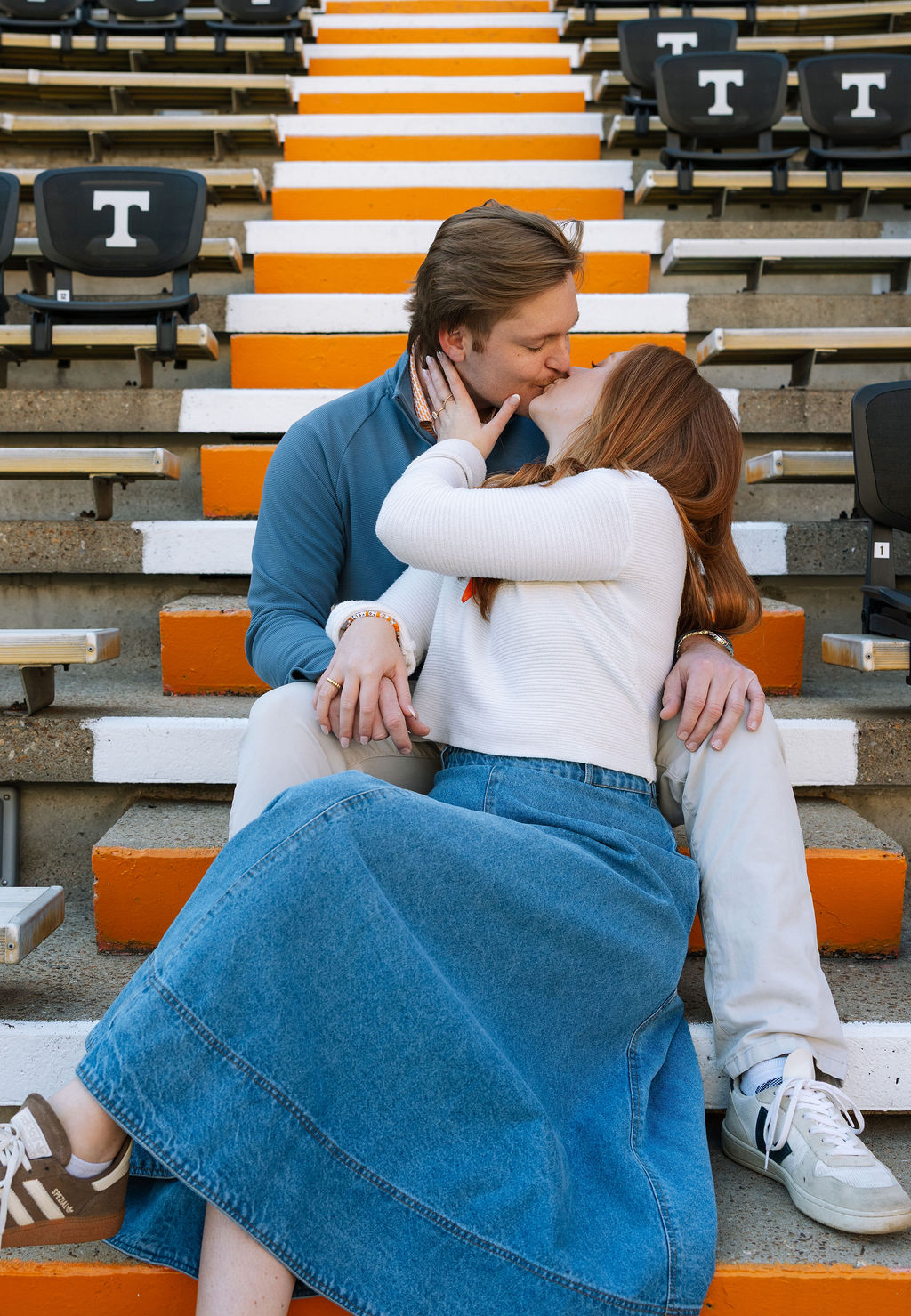 Engaged couple sitting together on Neyland Stadium steps during Knoxville engagement session