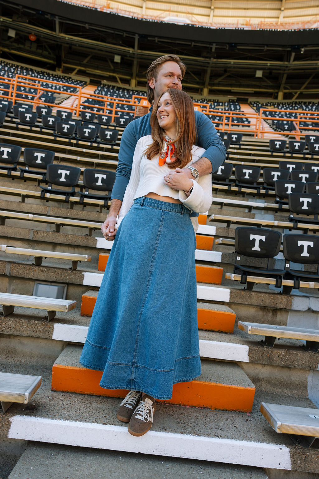 Newly engaged couple standing together in Neyland Stadium stands after Knoxville proposal