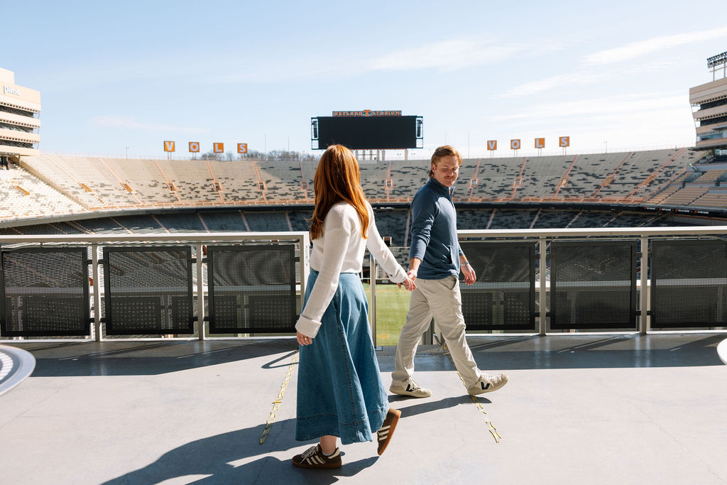 Couple walking together inside Neyland Stadium during Knoxville engagement photos