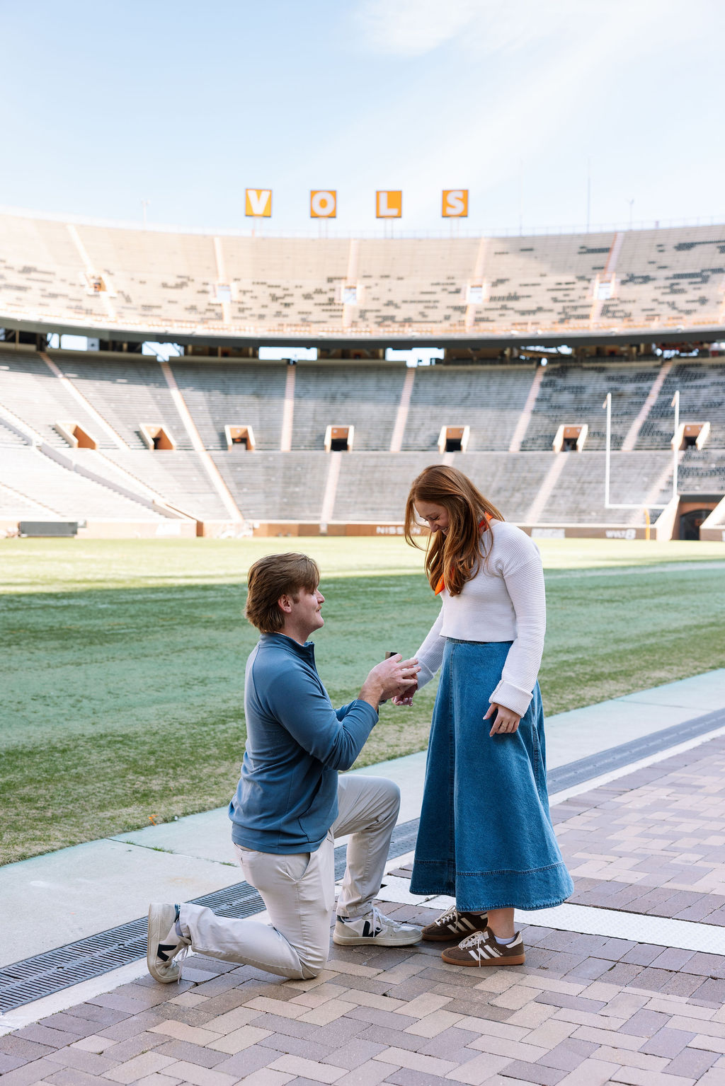 Man proposing on one knee during surprise proposal at Neyland Stadium in Knoxville