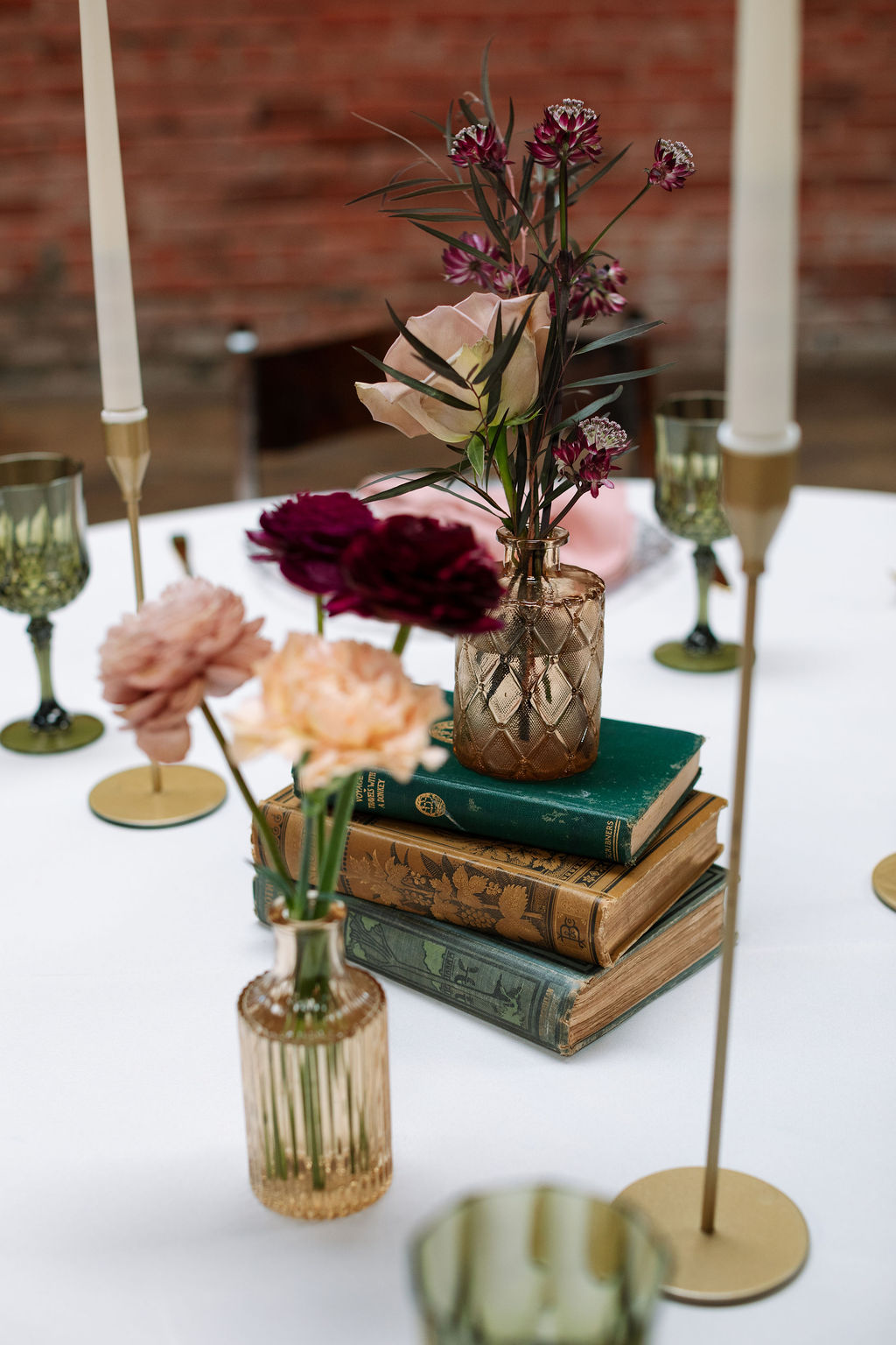 Wedding reception table with vintage books, florals, and candlelight, styled and photographed by a wedding photographer in Knoxville