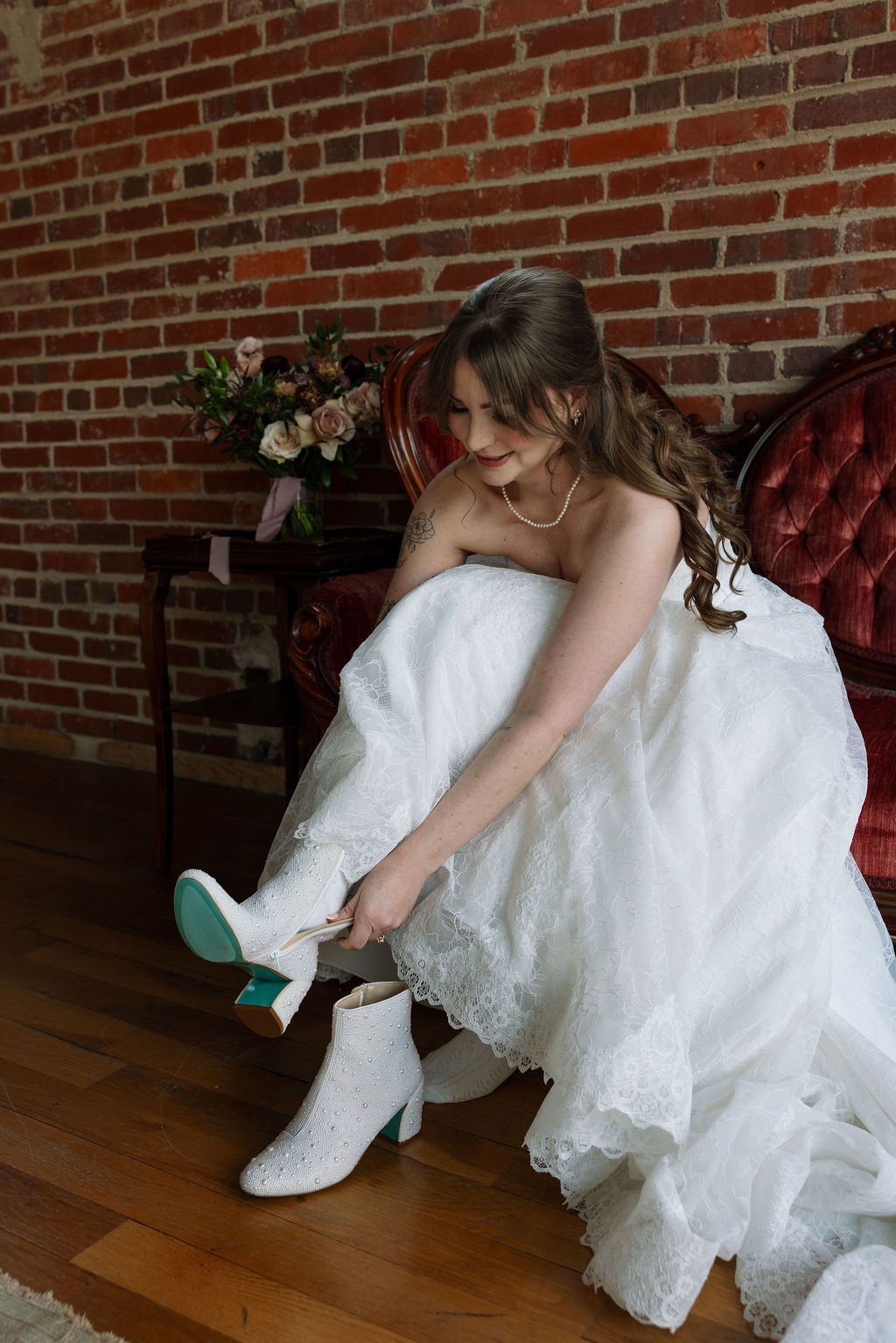 Bride putting on pearl-studded wedding boots while getting ready, photographed by a wedding photographer in Knoxville
