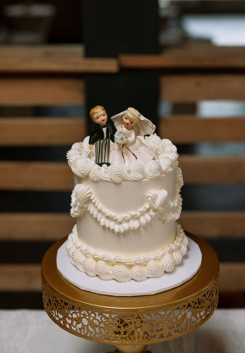 Small vintage-inspired wedding cake with bride and groom topper, captured by a wedding photographer in Knoxville