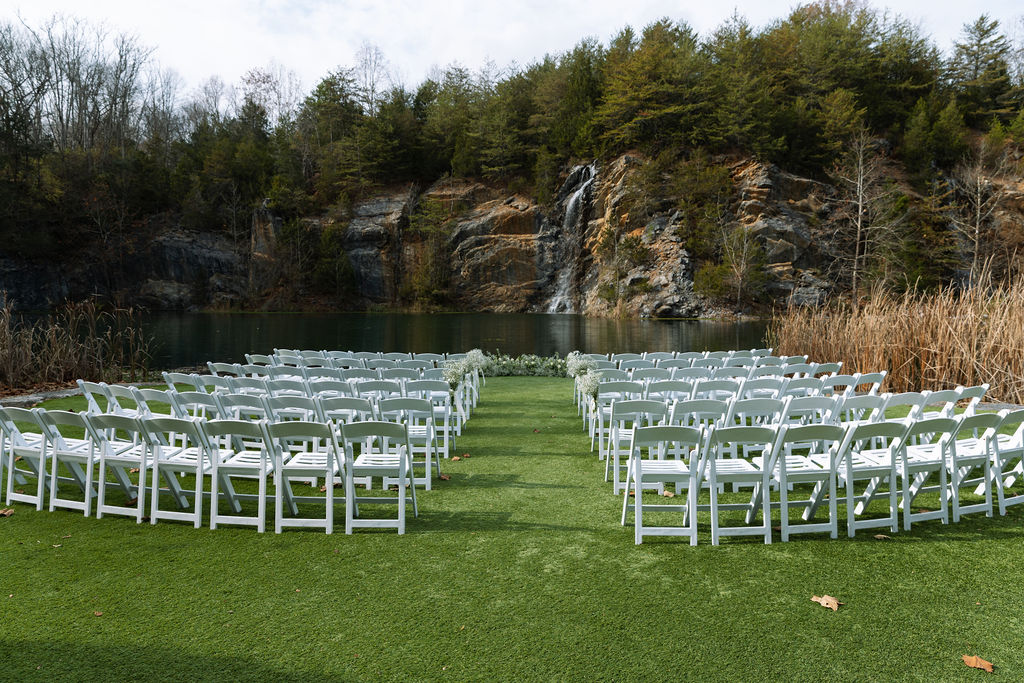 Outdoor wedding ceremony setup with white chairs and waterfall backdrop at Tennessee venue