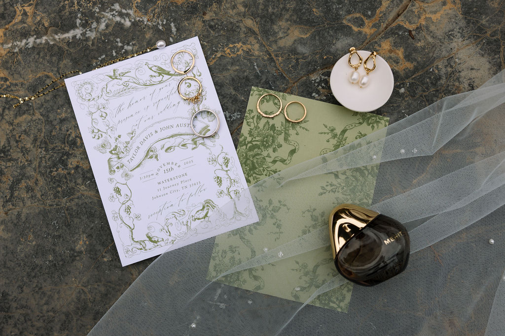 Wedding invitation suite with rings, earrings, and perfume detail photographed for candid wedding photography story