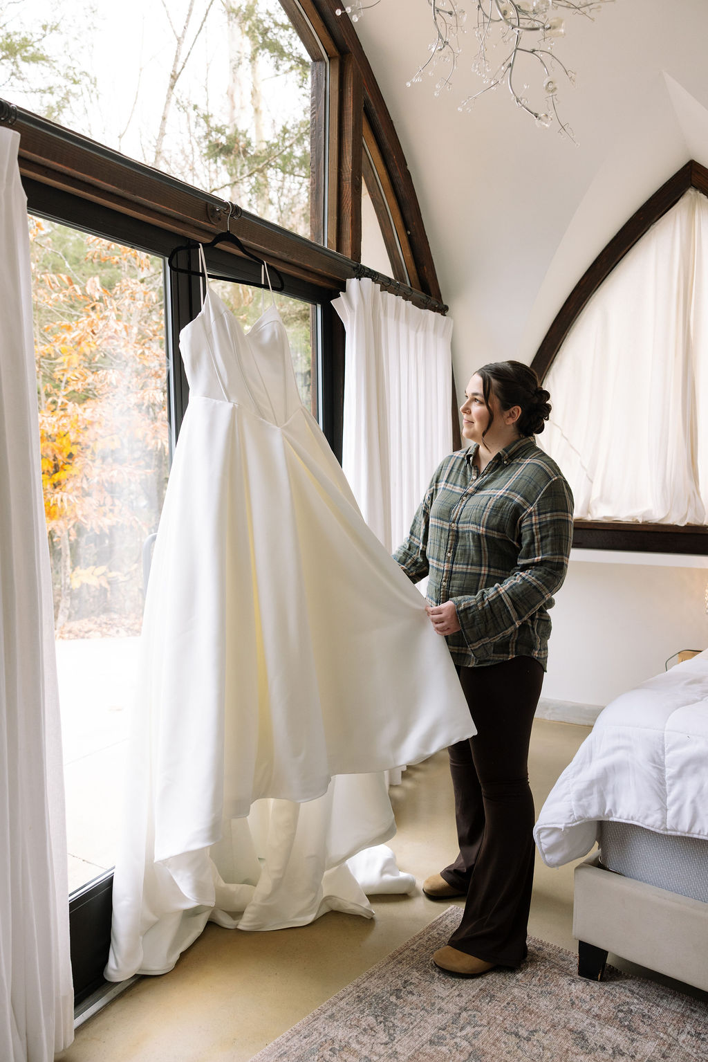 Bride admiring wedding dress by window before ceremony at Tennessee wedding venue