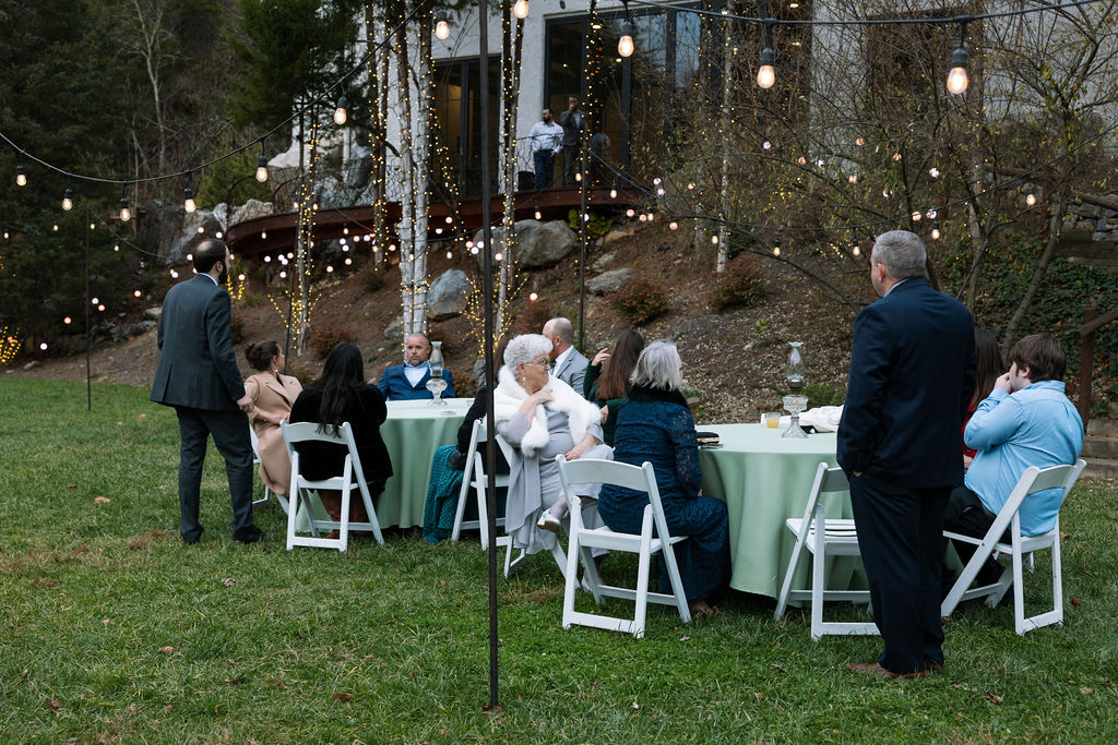 Wedding guests seated outdoors under string lights during relaxed Tennessee wedding reception