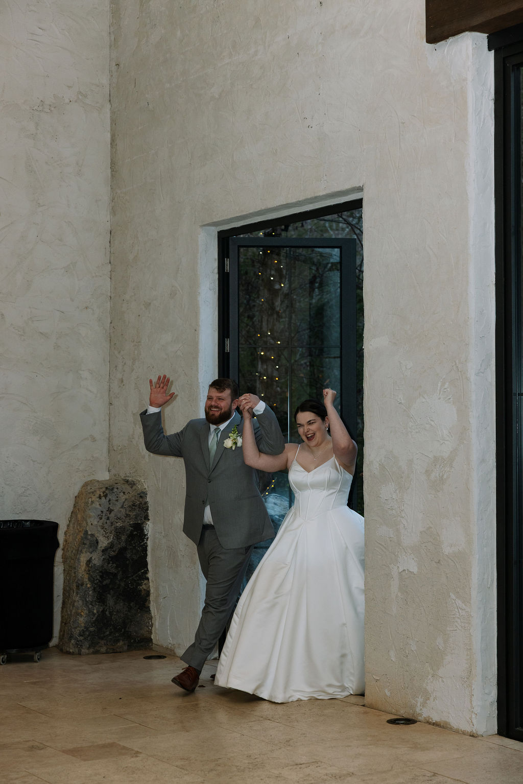 Bride and groom entering reception together during joyful candid wedding photography moment
