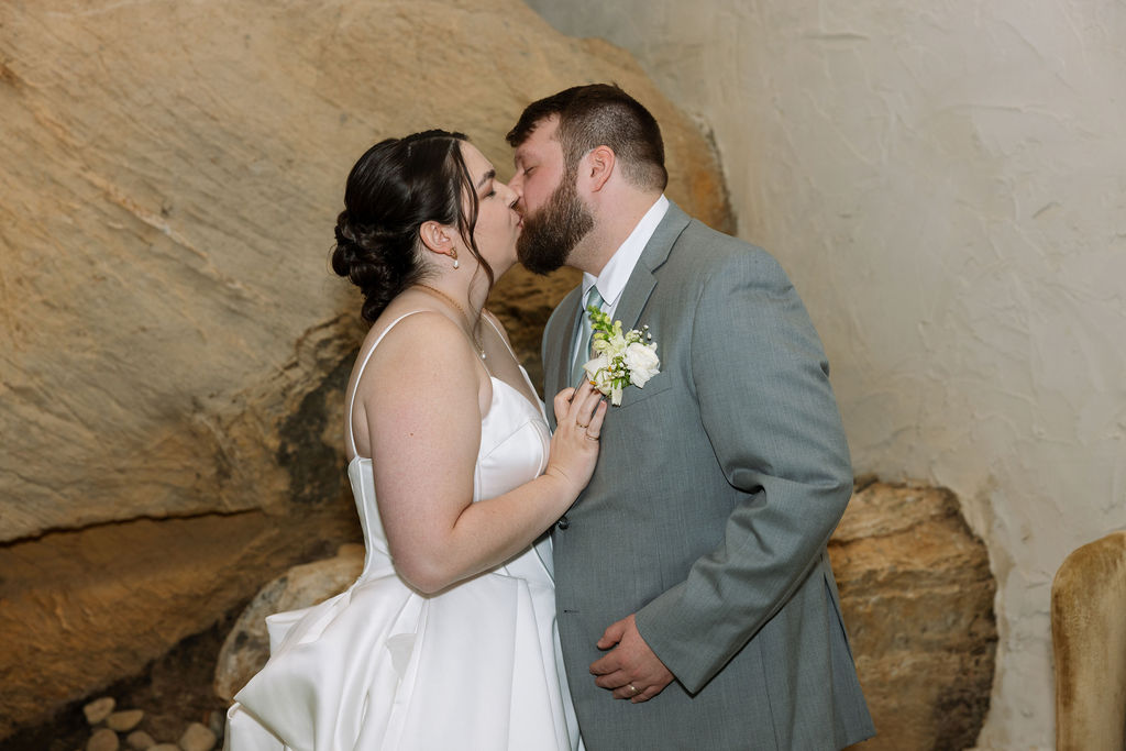Bride and groom kissing during indoor reception portraits captured with candid wedding photography