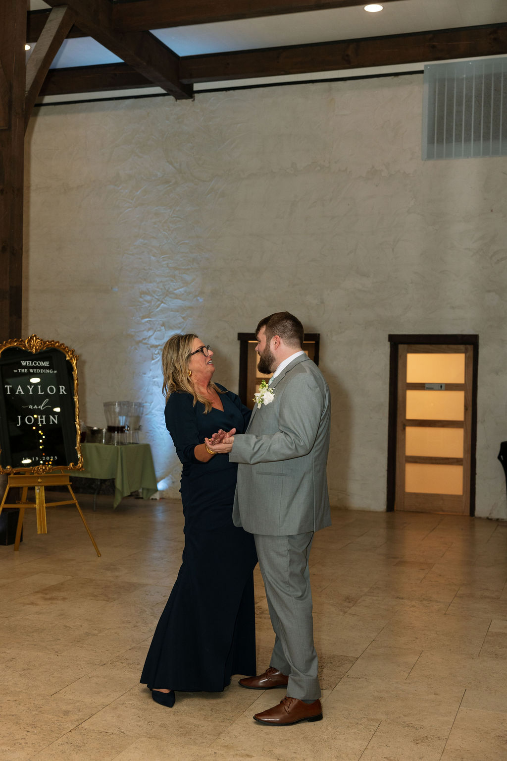 Groom dancing with mother during emotional reception moment captured with candid wedding photography
