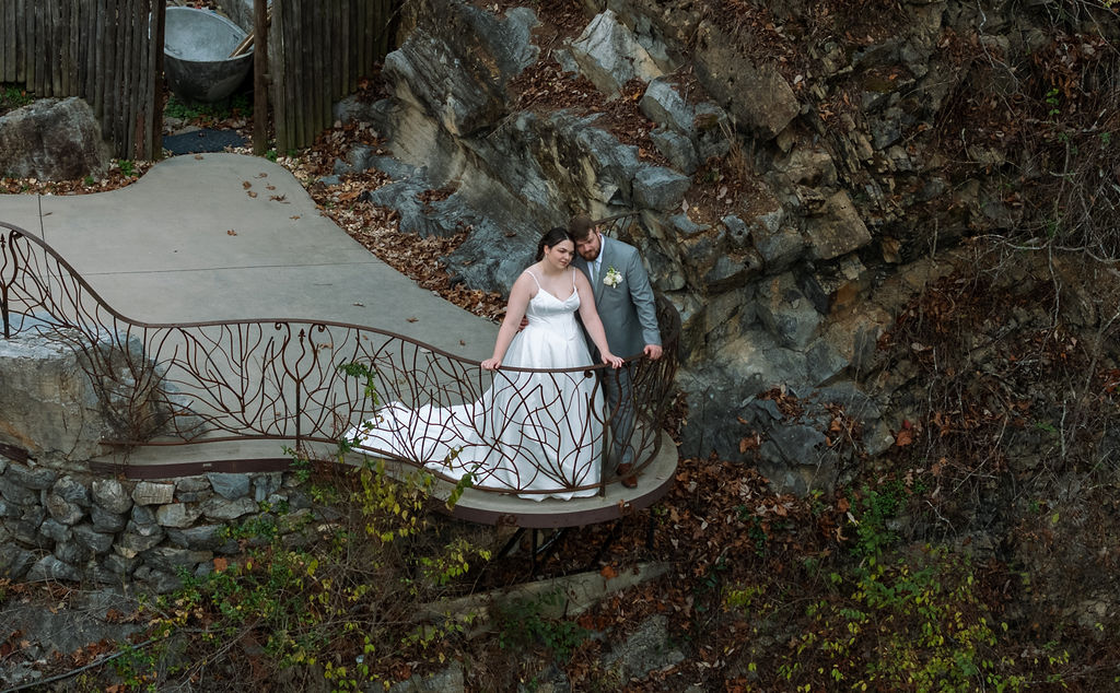 Bride and groom embracing on curved overlook balcony captured with candid wedding photography