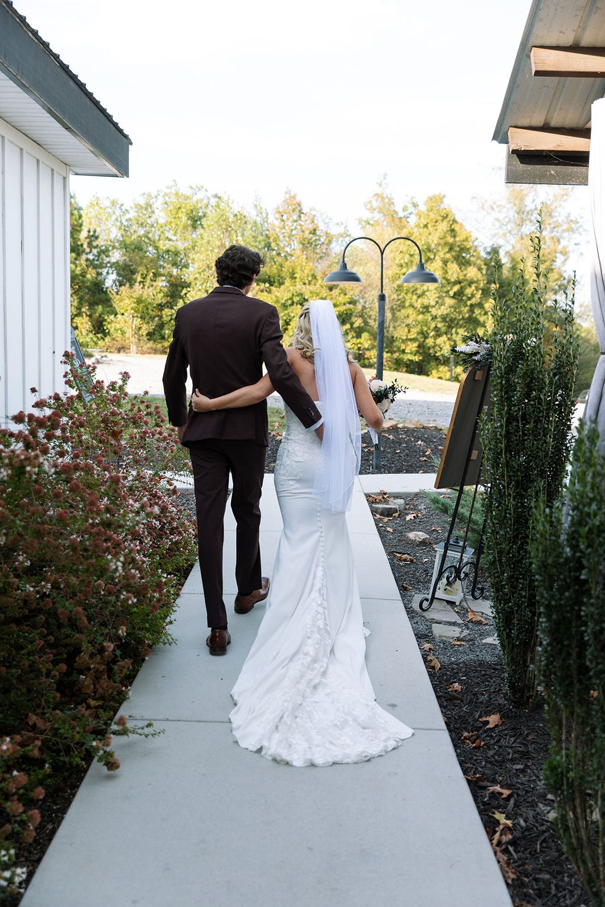 Bride and groom walking together behind venue after ceremony