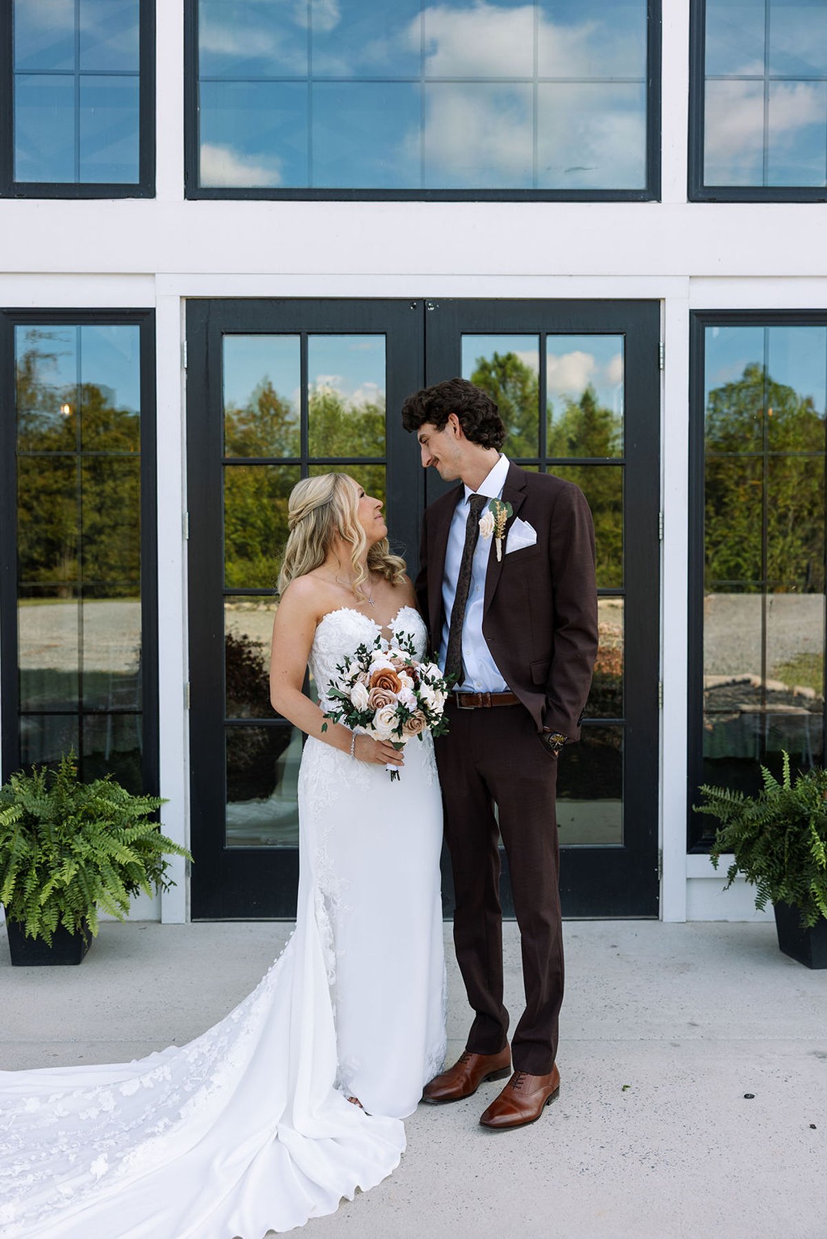 Tennessee wedding couple standing outside white venue with black framed doors