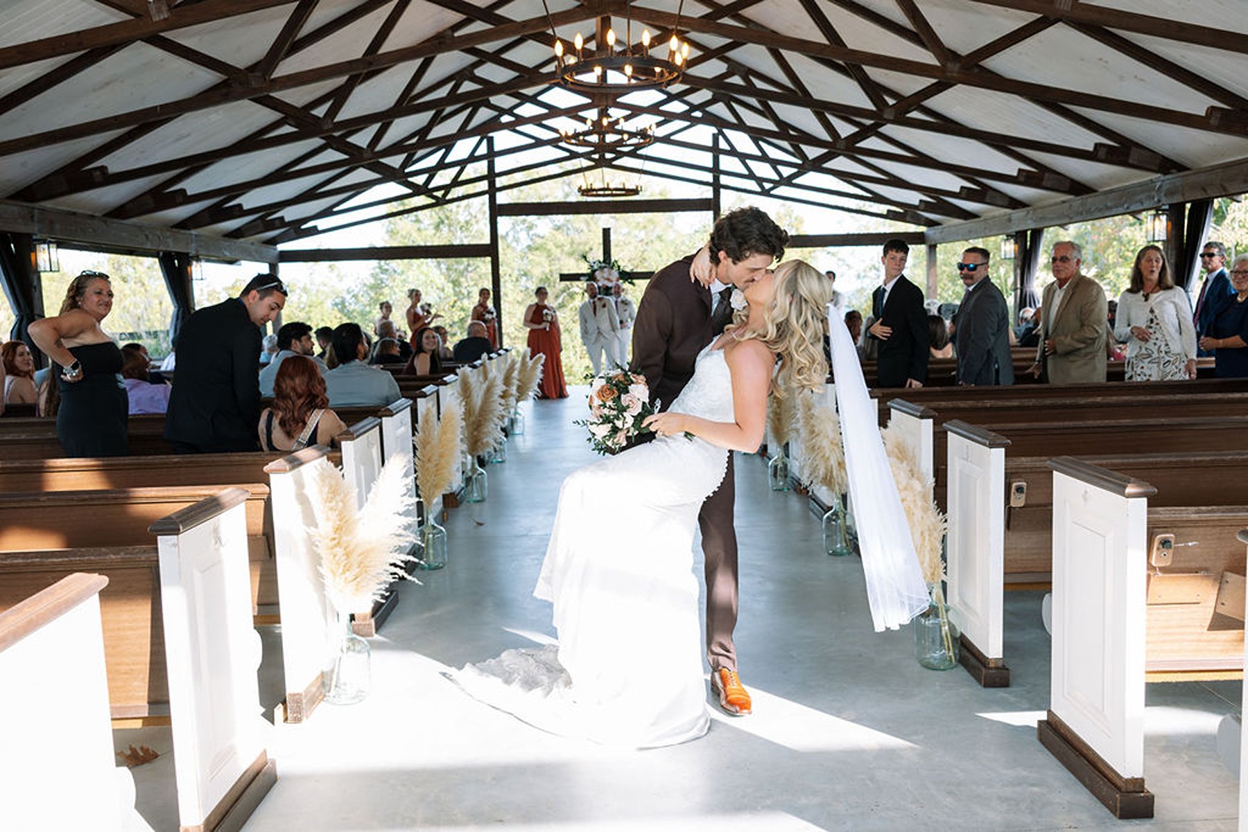 Tennessee wedding ceremony dip kiss in open-air chapel with wooden beams