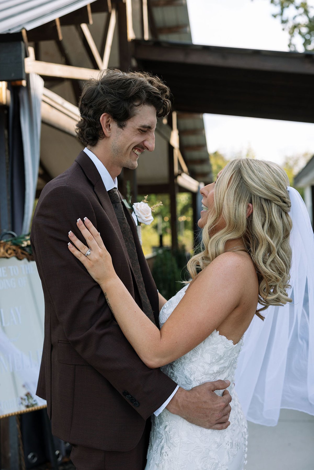Bride and groom laughing together under covered walkway after ceremony