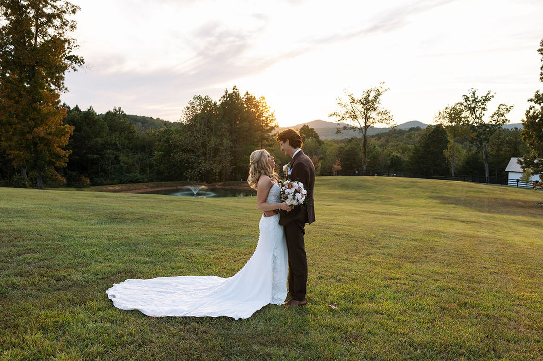 Wide Tennessee wedding sunset portrait with couple standing in open field