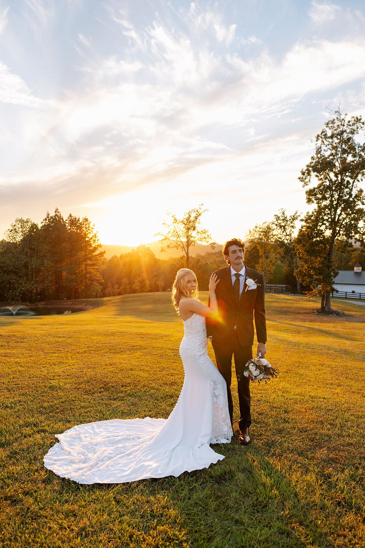 Tennessee wedding portrait with bride lifting dress as couple walks through sunset field