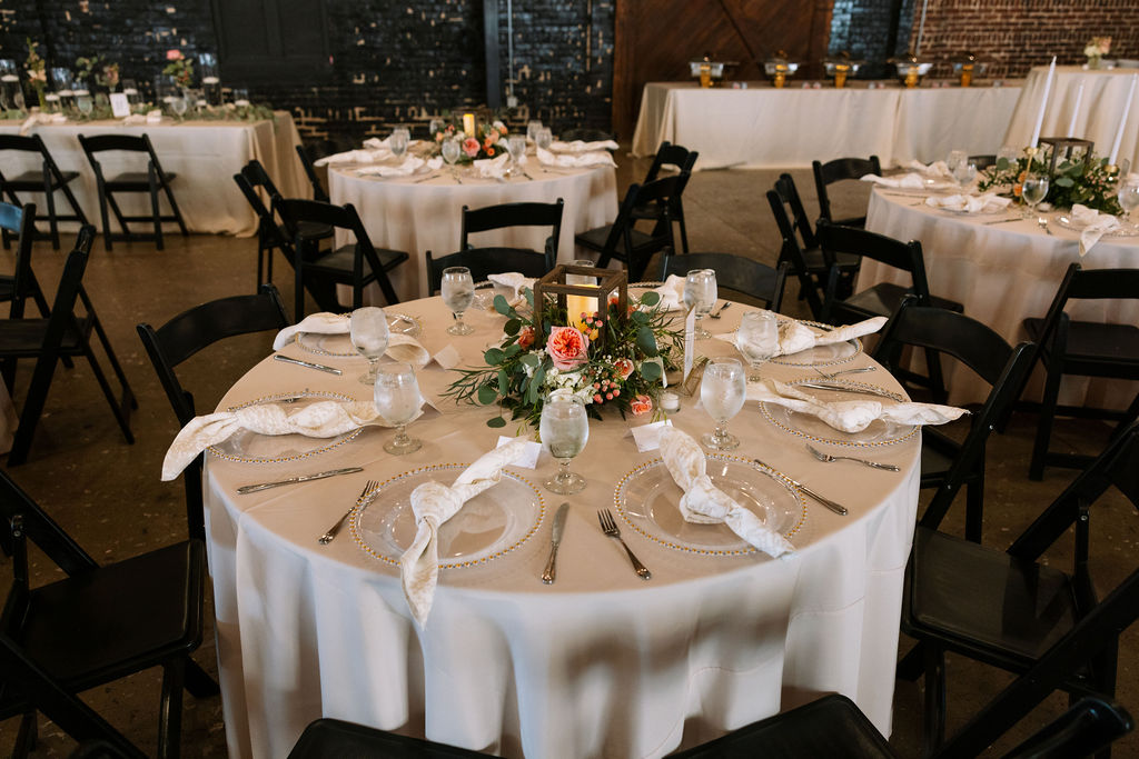 Reception table setup with neutral linens, glassware, and floral centerpiece inside Jackson Terminal Knoxville