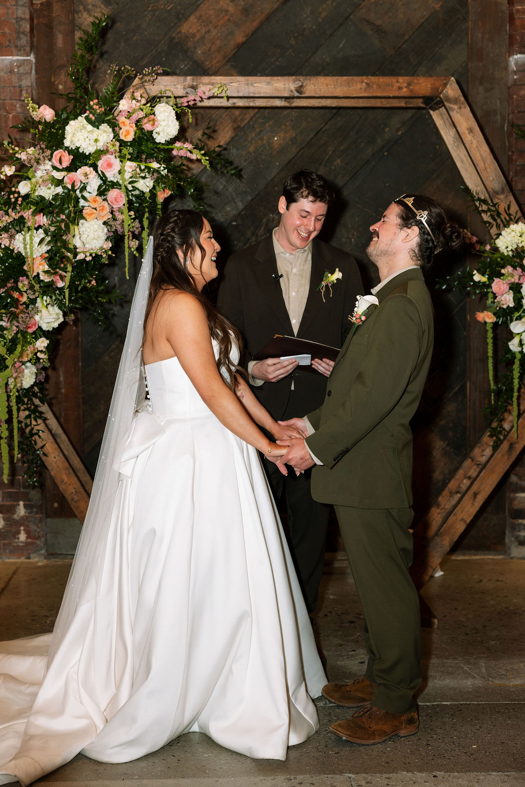 Bride and groom smiling during ceremony while holding hands at Jackson Terminal Knoxville