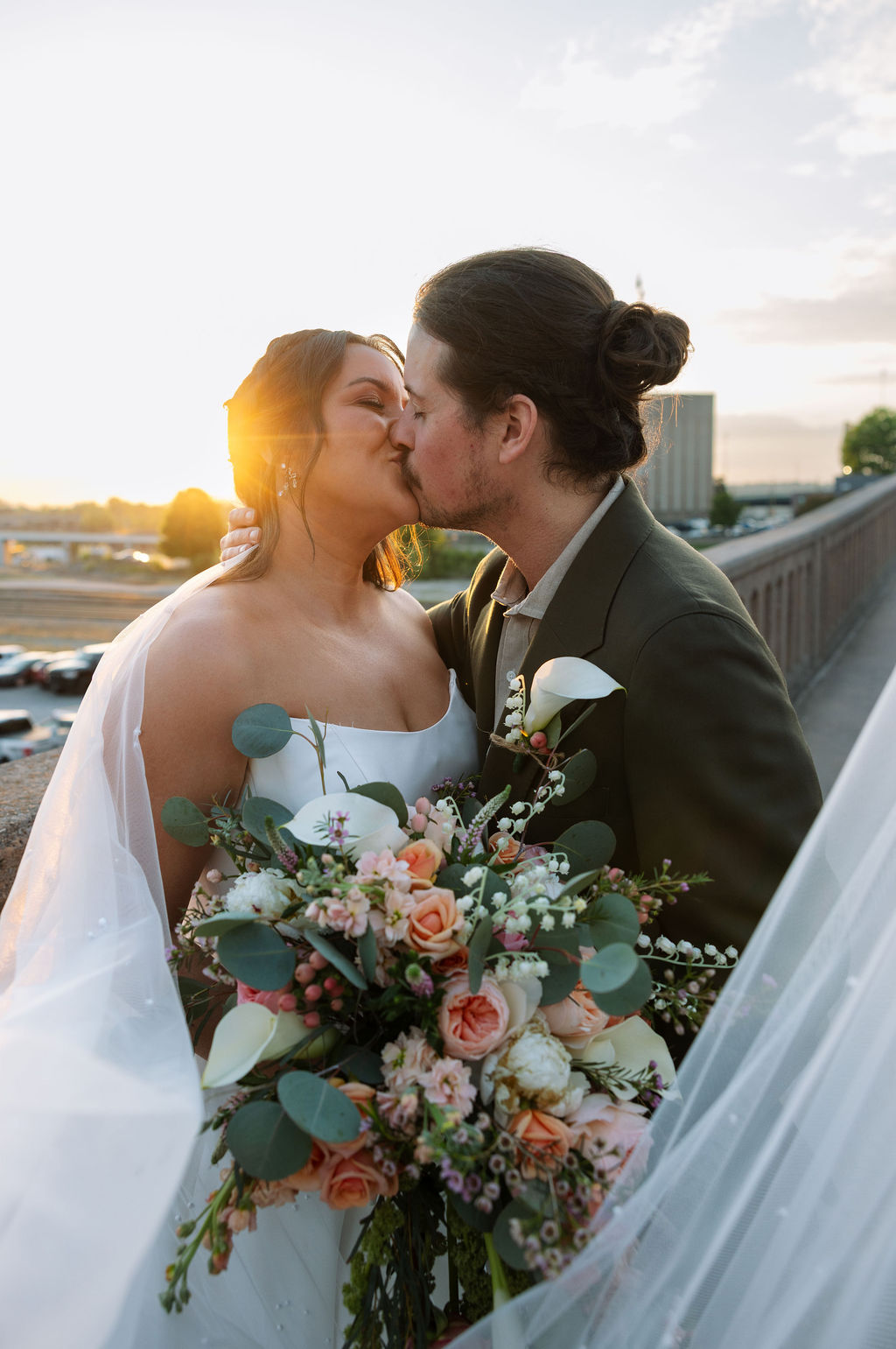 Bride and groom kissing during golden hour portraits on a downtown Knoxville bridge