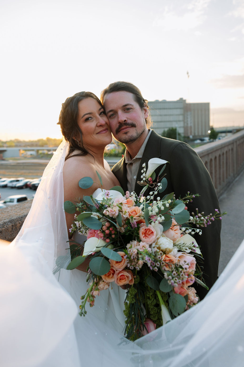 Bride and groom portrait at sunset on downtown Knoxville bridge with soft golden light