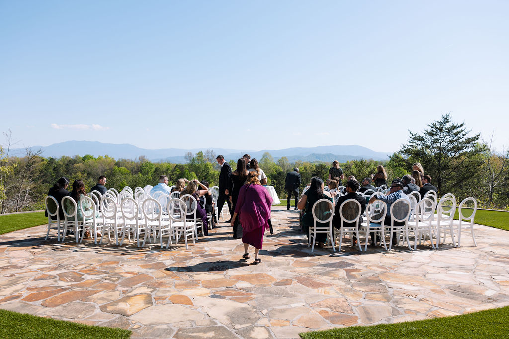 Outdoor ceremony setup with white chairs and mountain views in the background at a nichols heir wedding