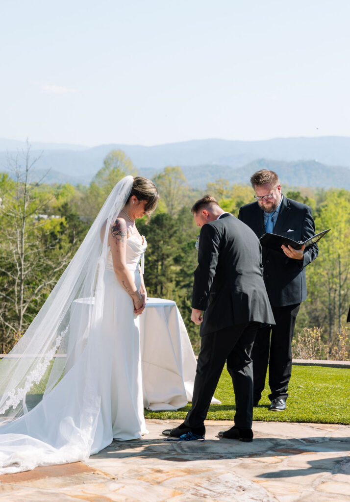 Bride and groom at altar during ceremony with mountain views behind them at a nichols heir wedding