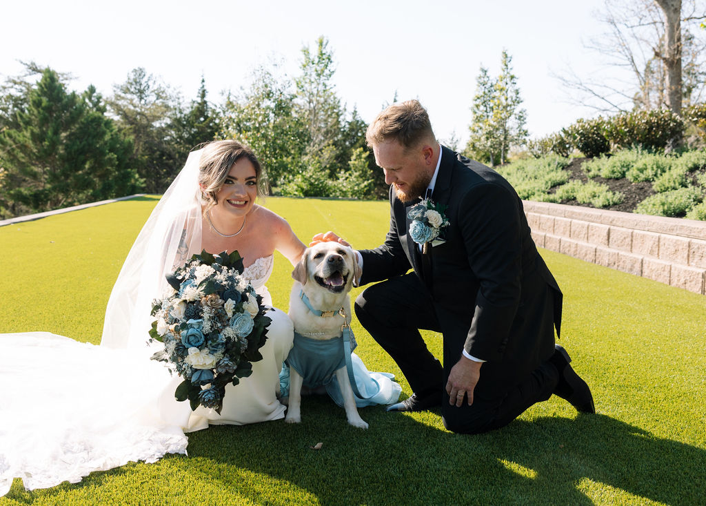 Bride and groom with their dog on the lawn, joyful candid wedding portrait outdoors