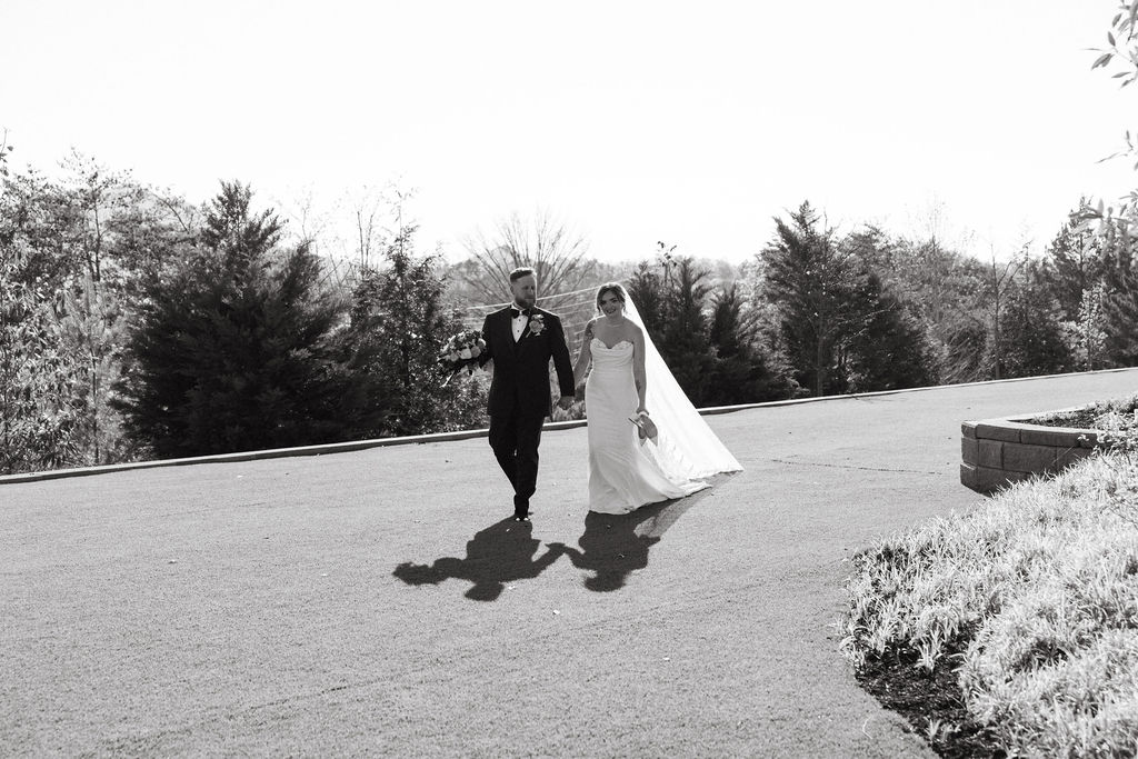 Black and white photo of bride and groom walking together outdoors after ceremony at a nichols heir wedding