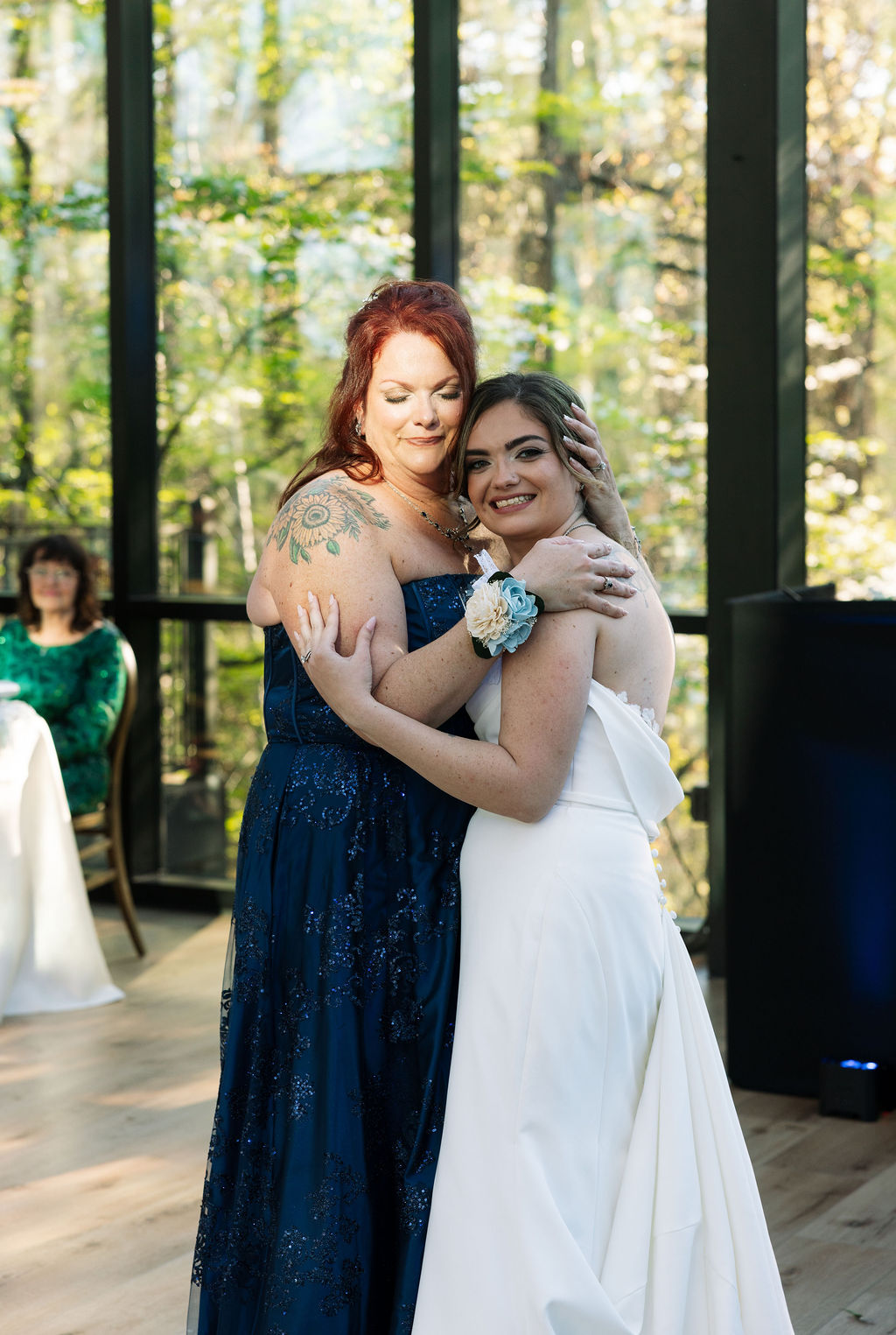 Bride sharing a hug with family member on dance floor during reception